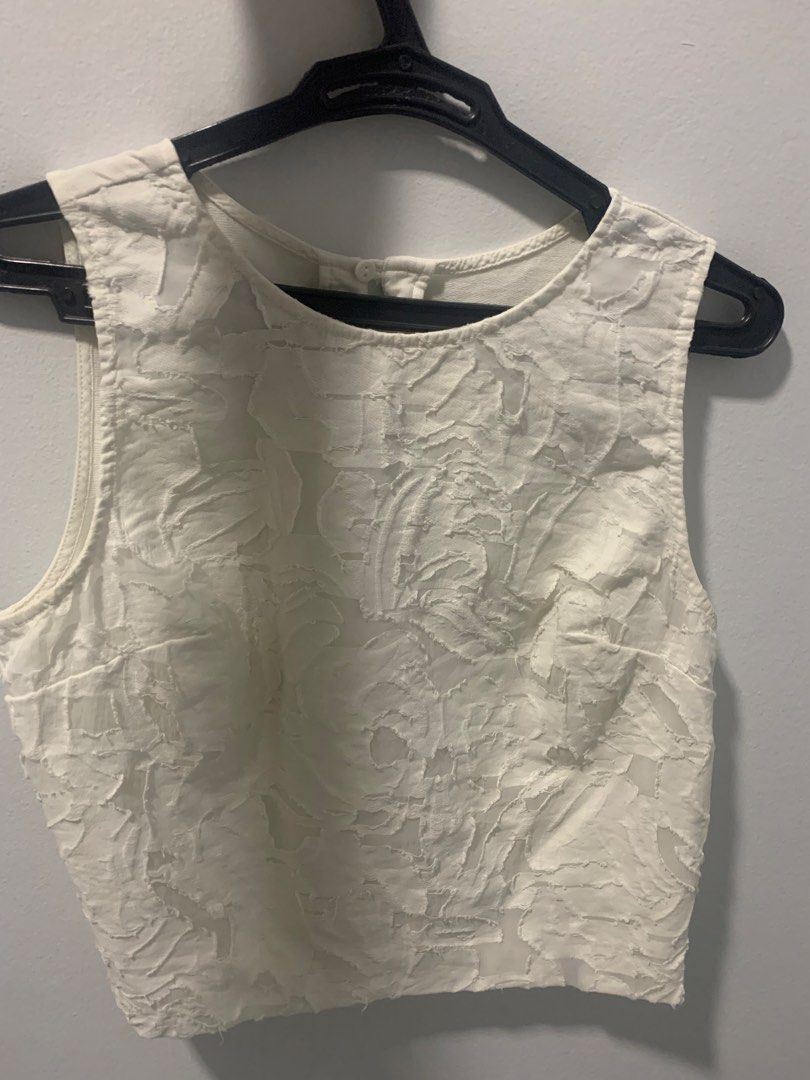 White Textured Sleeveless Crop Top (Category: Sleeveless) located in Manila. Submitted by decluterthings888 (Listing ID 1462821620, Image 1). Description: - White sleeveless crop top - Textured floral pattern - Round neckline - Button closure at the back - Cropped length (waist length) - Versatile for layering or wearing solo - Easy to dress up or down.