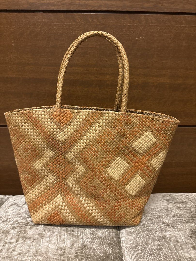 Woven Straw Tote Bag with Orange Pattern (Category: Tote Bags) located in Paranaque City. Submitted by corinne_see (Listing ID 1462838316, Image 1). Description: - Cute woven straw tote bag - Features a geometric orange and beige pattern - Braided handles for comfortable carrying - Zippered closure for security - Lined interior with a small pocket - Ideal for beach days or casual outings.
