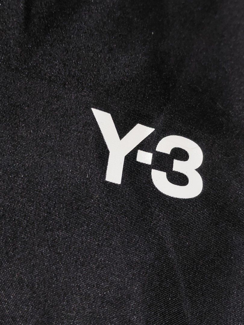Y-3 Black Drawstring Dust Bag (Category: Luxury Bags & Wallets) located in Pozorrubio. Submitted by aquidafinds (Listing ID 1462815796, Image 2). Description: - Black Y-3 dust bag - White Y-3 logo print - Dual drawstring closure - Ideal for storing shoes or accessories - Approximate dimensions: 15 inches x 12 inches - Made from smooth synthetic fabric.
