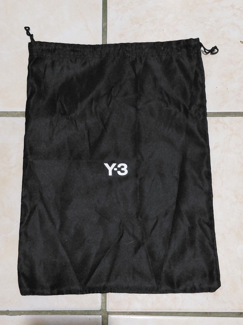 Y-3 Black Drawstring Dust Bag (Category: Luxury Bags & Wallets) located in Pozorrubio. Submitted by aquidafinds (Listing ID 1462815796, Image 1). Description: - Black Y-3 dust bag - White Y-3 logo print - Dual drawstring closure - Ideal for storing shoes or accessories - Approximate dimensions: 15 inches x 12 inches - Made from smooth synthetic fabric.