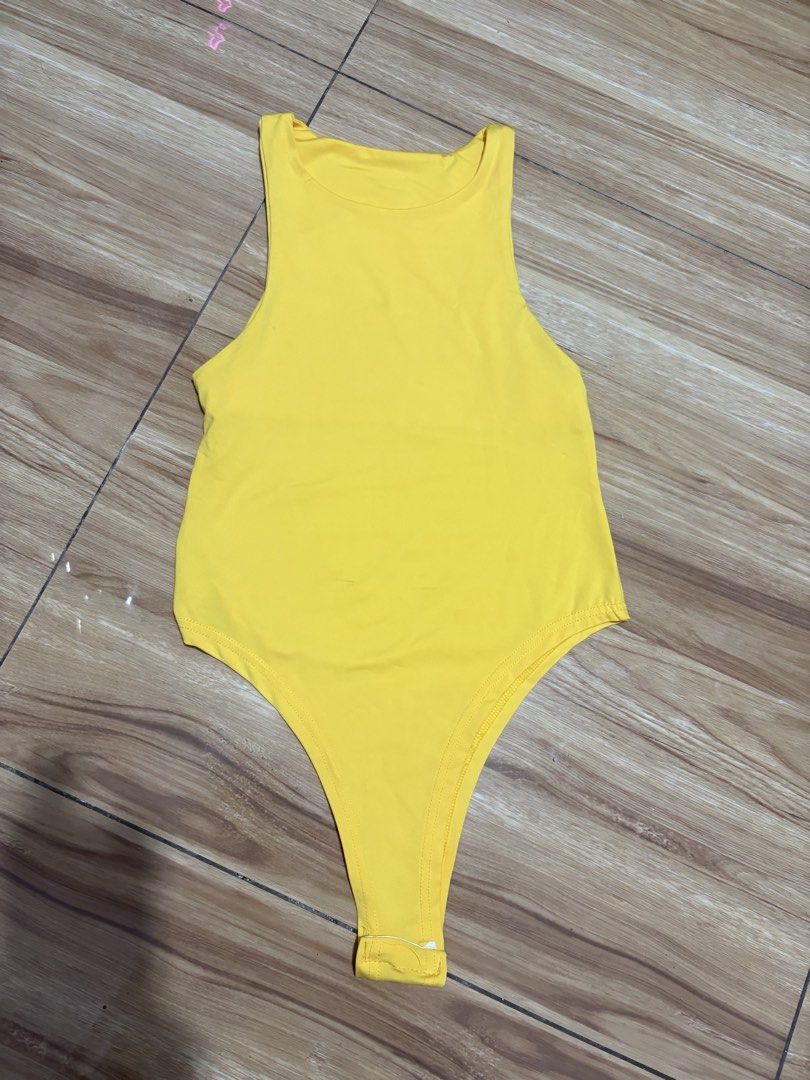Yellow Sleeveless Bodysuit Snap Crotch (Category: Sleeveless) located in Quezon City. Submitted by kyjnll (Listing ID 1462880800, Image 2). Description: Used once only - Bright yellow sleeveless bodysuit - High neckline with racerback design - Thong bottom with convenient snap closure at crotch - Stretchy material for ultimate comfort - Versatile piece: great for layering or as a standalone top - Pairs perfectly with jeans or skirts.