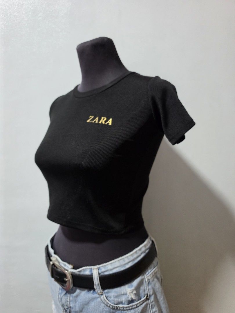 Zara Black Ribbed Cropped Top small (Category: Shirts) located in Paranaque City. Submitted by franinnashop (Listing ID 1462691605, Image 2). Description: - Zara black ribbed crop top - Short sleeves - Crew neck - Gold Zara logo detail on front - Comfortable and stretchy material - Easy to style with high-waisted jeans or skirts - Perfect for casual or dressed-up looks declutter small paranaque city.