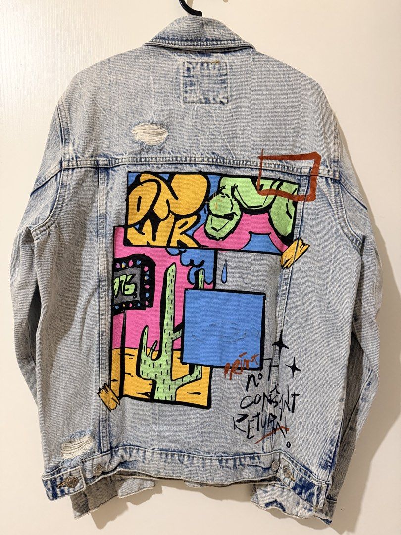 Zara Distressed Denim Jacket with Graffiti Art (Category: Coats, Jackets and Outerwear) located in Makati City. Submitted by viajero_republic (Listing ID 1462700802, Image 3). Description: - Cool Zara denim jacket - Light wash with distressed details - Unique graffiti-style art on front and back - Button closure - Long sleeves - Perfect statement piece for your wardrobe.
