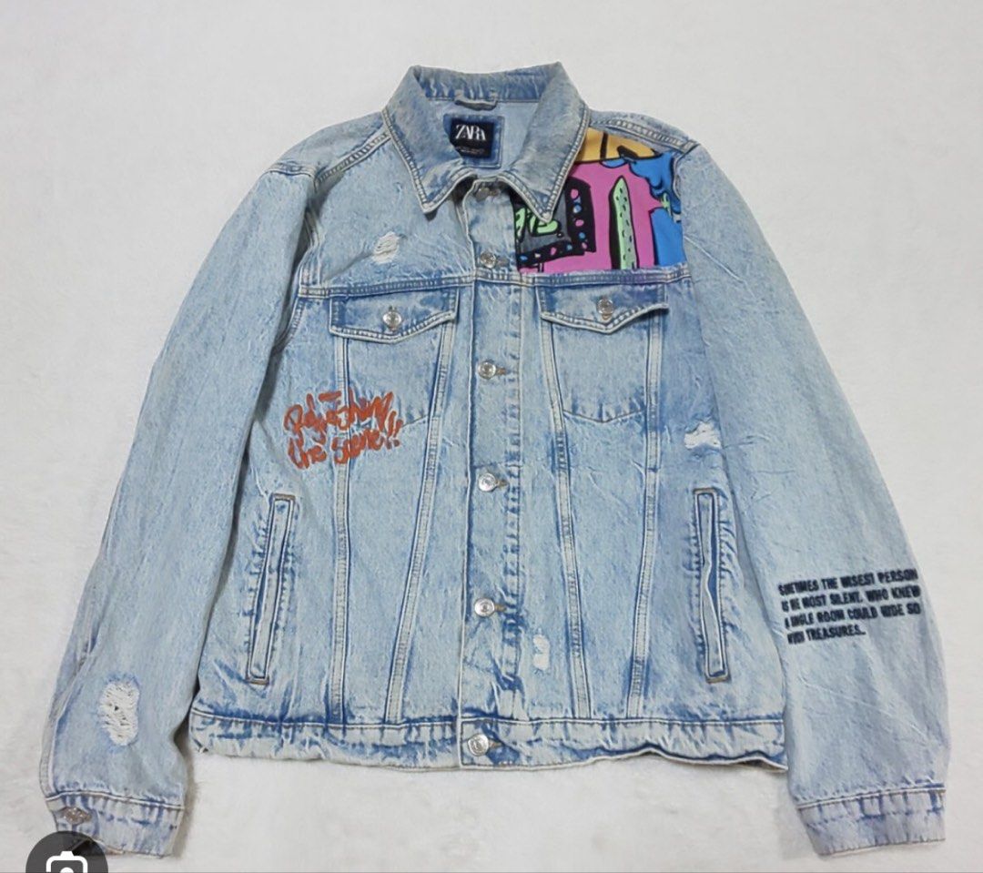 Zara Distressed Denim Jacket with Graffiti Art (Category: Coats, Jackets and Outerwear) located in Makati City. Submitted by viajero_republic (Listing ID 1462700802, Image 1). Description: - Cool Zara denim jacket - Light wash with distressed details - Unique graffiti-style art on front and back - Button closure - Long sleeves - Perfect statement piece for your wardrobe.