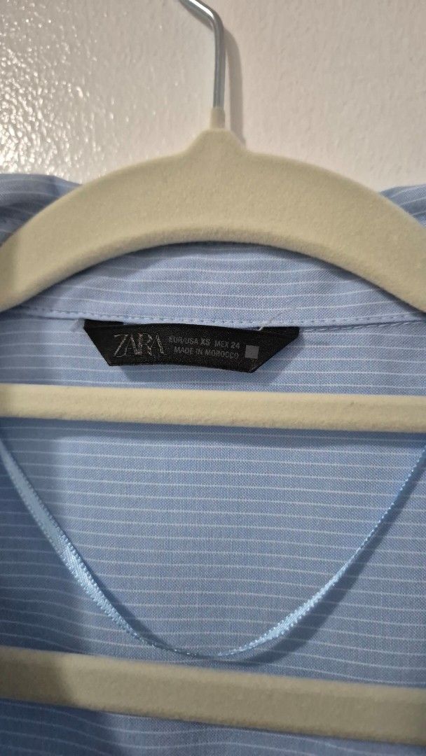 Zara Light Blue Pinstripe Button-Up Shirt (Category: Tshirts & Polo Shirts ) located in Pasig City. Submitted by magnoliafern (Listing ID 1462816498, Image 2). Description: - Zara light blue button-up shirt - Subtle pinstripe pattern - Made in Morocco - Material: 56% Cotton, 44% Polyester - Versatile for casual or work attire.