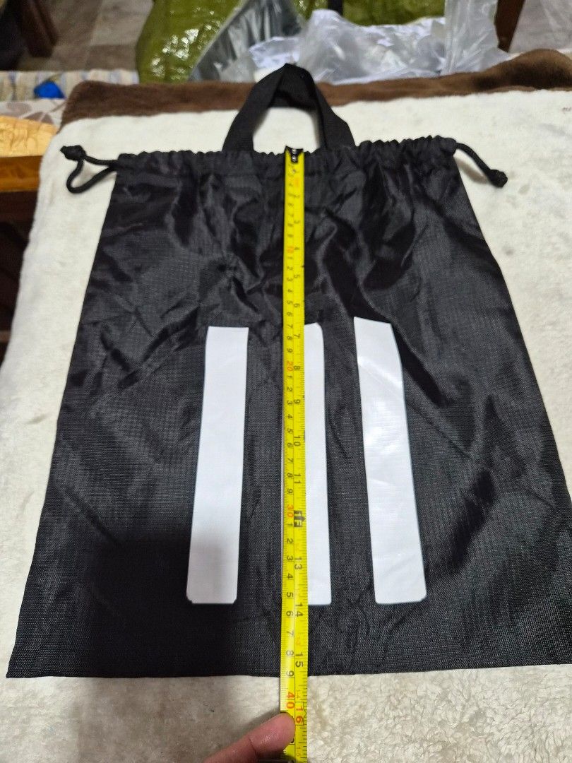 Adidas Drawstring Bag Black Three Stripes (Category: Backpacks) located in Mandaue City. Submitted by chuchi152615 (Listing ID 1459167552, Image 3). Description: - Classic black Adidas drawstring bag - Features iconic three stripes design - Equipped with two convenient handles for carrying - Ideal for gym sessions or everyday errands - Approximate dimensions: 15 inches (length) x 16 inches (height).