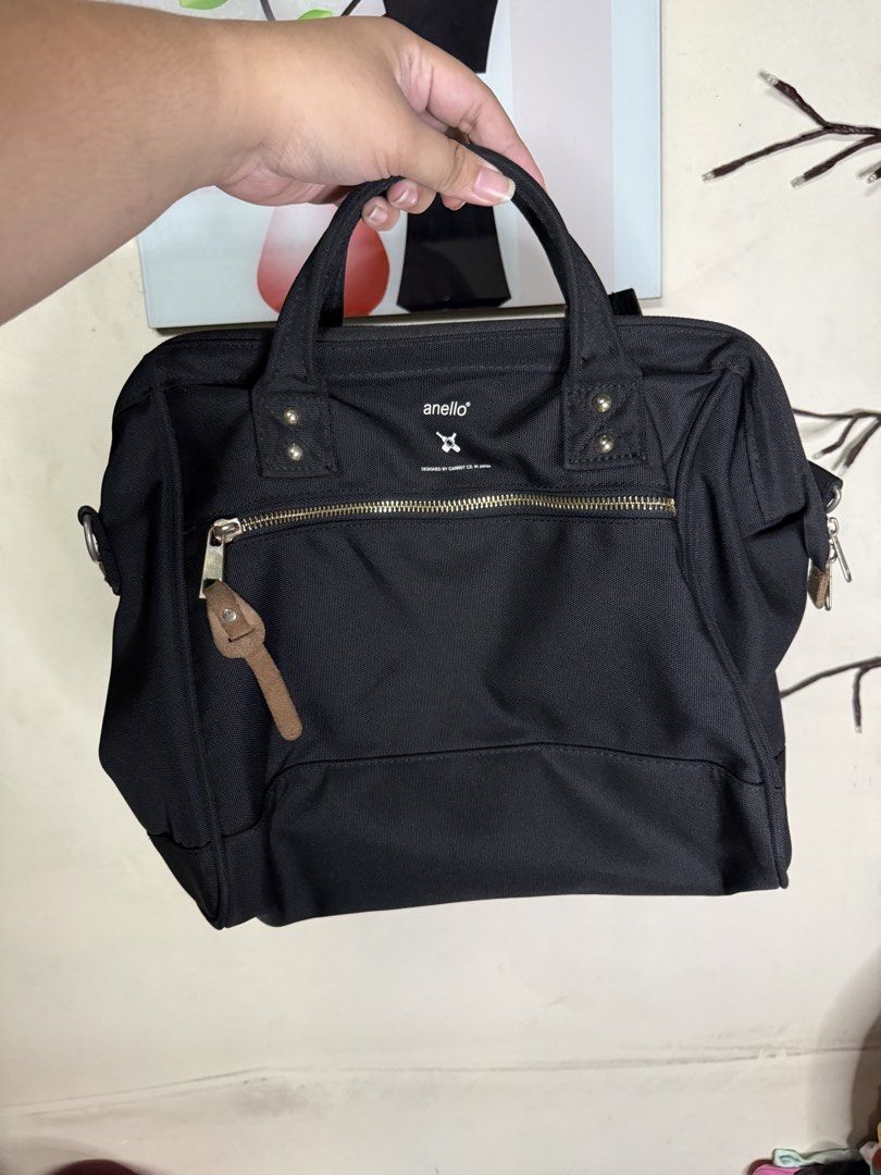Anello Black Canvas Two-way Bag (Category: Backpacks) located in Taytay. Submitted by bellakutch (Listing ID 1459269641, Image 1). Description: - Anello black canvas bag - Top handles and detachable shoulder strap - Multiple interior pockets for organization - Front zipper pocket - Gold-tone hardware - Ideal for everyday use or travel.