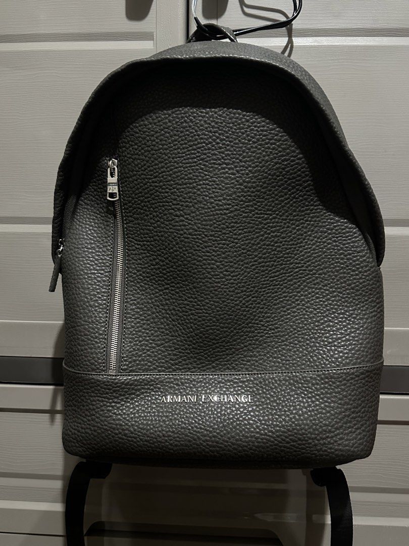 Armani Exchange Logo Plaque Backpack (Category: Backpacks) located in Antipolo. Submitted by ttrends (Listing ID 1459231555, Image 2). Description: - Grey Armani Exchange backpack - Pebble texture faux leather - Front zip pocket - Main compartment - Padded straps and back panel for comfort - Internal laptop sleeve - Small internal zip pocket - Ideal for everyday use or travel RFS: too many bags.
