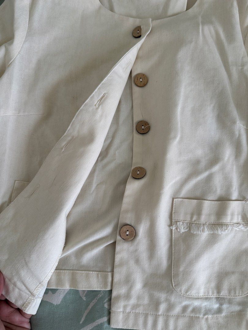 Beige Button-Up Jacket with Pocket Details (Category: Coats, Jackets and Outerwear) located in Paranaque City. Submitted by declutterwyae (Listing ID 1459138029, Image 2). Description: - Lightweight beige jacket - Features wooden buttons down the front - Two front pockets with frayed edges - Long sleeves with frayed cuffs - Simple and versatile, great for layering.