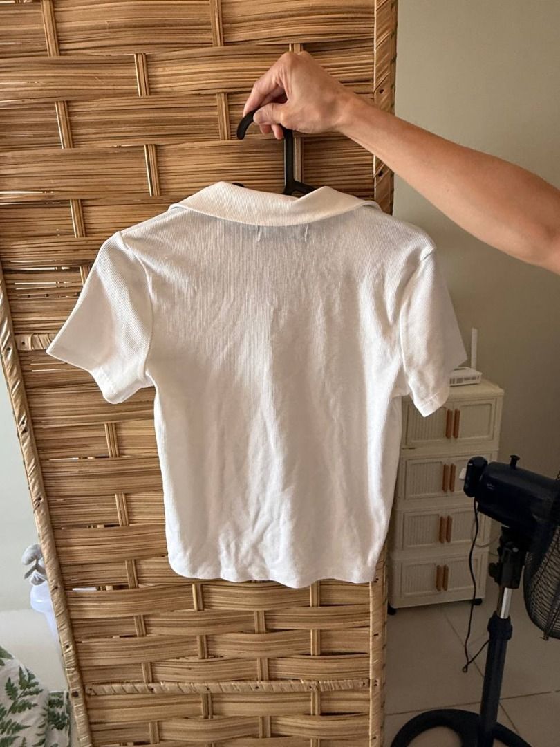Bershka White Collared Zip Up Cropped Top (Category: Blouses) located in Manila. Submitted by jimmy_juniorrr (Listing ID 1459177841, Image 2). Description: - White Bershka cropped top - Short sleeves - Collared neckline - Zip-up front - Textured fabric - Versatile: pairs well with high-waisted jeans or skirts - Suitable for casual or dressed-up looks.