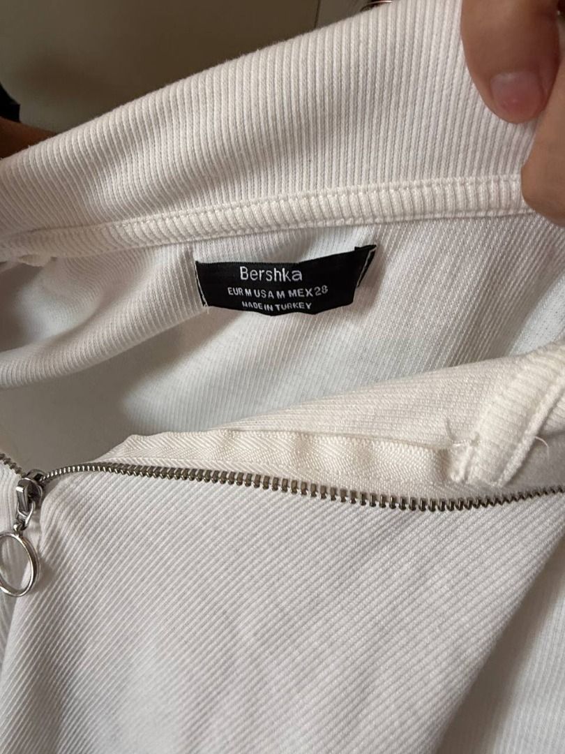 Bershka White Collared Zip Up Cropped Top (Category: Blouses) located in Manila. Submitted by jimmy_juniorrr (Listing ID 1459177841, Image 3). Description: - White Bershka cropped top - Short sleeves - Collared neckline - Zip-up front - Textured fabric - Versatile: pairs well with high-waisted jeans or skirts - Suitable for casual or dressed-up looks.