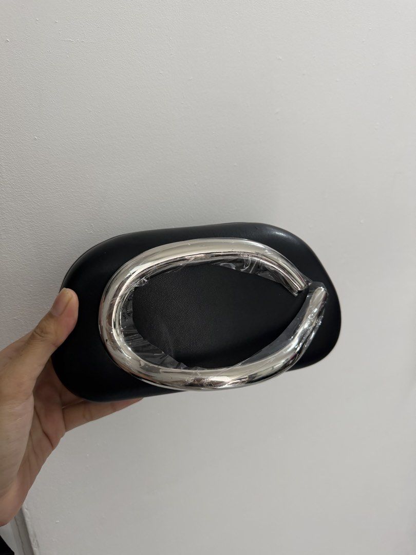 Black Clutch Bag with Silver Handle (Category: Clutches) located in Pasig City. Submitted by miss_abuelita (Listing ID 1459150385, Image 2). Description: - Elegant black clutch bag - Features a shiny silver handle, still protected by plastic wrap - Includes a detachable silver chain strap for versatile carrying - Ideal for evening events and special occasions.