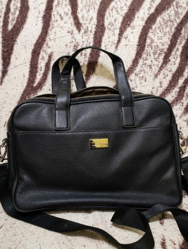Black Leather Laptop Bag with Shoulder Strap (Category: Laptop Bags & Sleeves) located in Caloocan City. Submitted by magtaanber_moon (Listing ID 1459262628, Image 1). Description: - Black pebbled leather bag - Top handles and detachable shoulder strap - Gold-tone metal logo plate on front - Zip-top main compartment - Spacious interior, fits laptop and essentials - Ideal for work or travel.