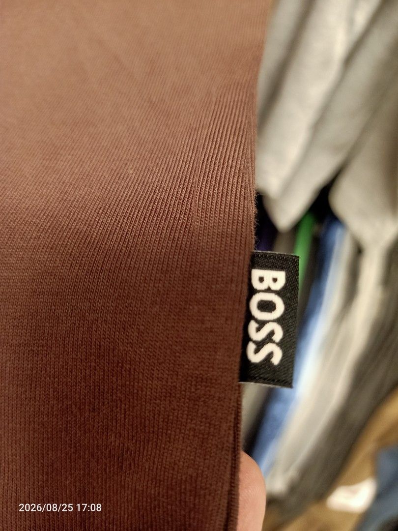 BOSS T-Shirt authentic (Category: Tshirts & Polo Shirts ) located in Las Pinas. Submitted by OmengSoyT (Listing ID 1459184997, Image 3). Description: - Brand new BOSS t-shirt collarless -Authentic with complete scannable hang tags -Mocha Brown color -Size Large(L) regular fit - Features the iconic upside down "B" logo prominently on the chest. - Includes a subtle circular leather patch detail. - Made from comfortable, high-quality mercerised cott