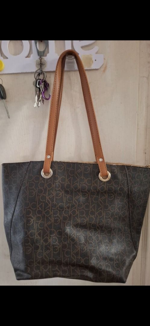 Calvin Klein Monogram Tote Bag (Category: Luxury Bags & Wallets) located in Cavite. Submitted by chinkee0215020 (Listing ID 1459163601, Image 1). Description: - Brown Calvin Klein tote bag - Signature monogram print - Tan leather straps and trim - Multiple interior compartments - Interior zippered pocket - Clean interior - Ideal for everyday essentials.