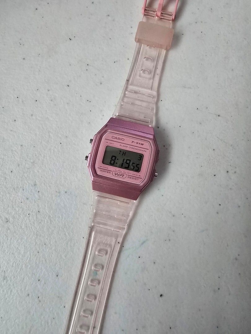 Casio F-91W Pink Digital Watch (Category: Women's Watches) located in Quezon City. Submitted by mariescloset2020 (Listing ID 1459285589, Image 1). Description: - Classic Casio F-91W digital watch - Trendy pink casing - Clear, transparent strap - Displays time and date - Built-in stopwatch function - Water resistant - Perfect retro accessory for everyday style.