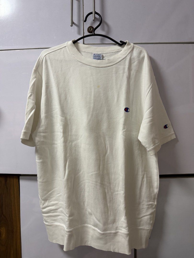 Champion White T-Shirt with Logo (Category: Tshirts & Polo Shirts ) located in Cainta. Submitted by tinpalma (Listing ID 1459130271, Image 1). Description: - White Champion T-shirt - Size: XX-Large but fits to M-L - Features classic Champion logo on chest and sleeve - Minor yellow stain near collar - Ideal for casual wear.