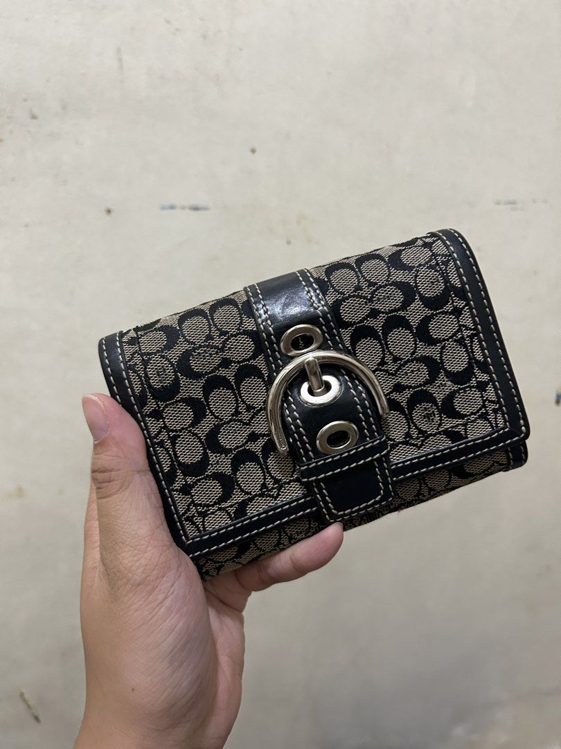 Coach Soho Wallet (Category: Luxury Bags & Wallets) located in Manila. Submitted by ririririri25252 (Listing ID 1459250888, Image 1). Description: - Authentic Coach wallet in signature C monogram pattern - Stylish black leather trim and silver buckle closure - Ample card slots and a convenient coin pocket - Compact size, fits easily in any bag - Ideal for everyday use.