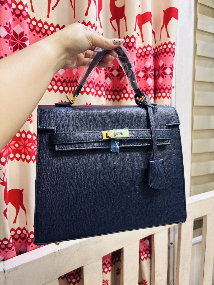 Dark Blue Structured Handbag with Gold Hardware (Category: Luxury Bags & Wallets) located in Quezon City. Submitted by itsmeriaa (Listing ID 1459248323, Image 1). Description: Hermés dark blue structured handbag with gold clasp. Features top handle, detachable strap, and saffiano-like leather. Spacious interior, perfect for work or daily use. Hardware still has protective plastic..
