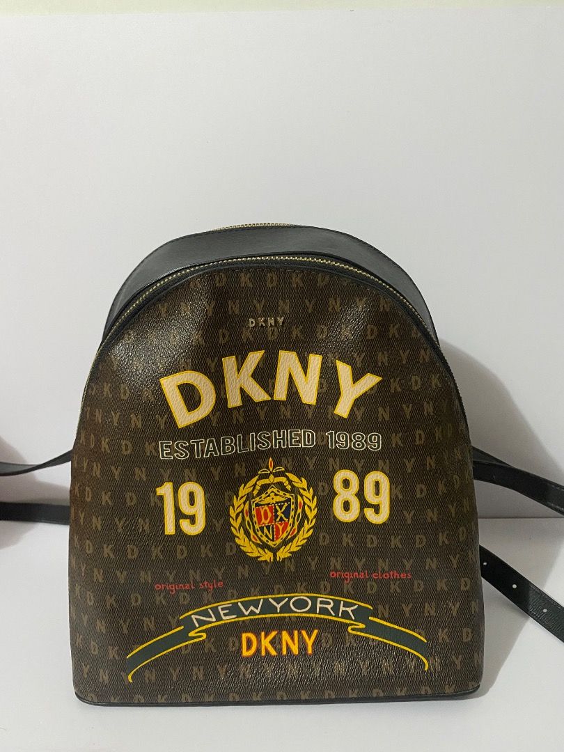 DKNY Established 1989 New York Backpack (Category: Backpacks) located in Caloocan City. Submitted by wrenessie (Listing ID 1459229060, Image 1). Description: - DKNY backpack with all-over logo print - Black leather accents on top and straps - Gold zippers - Front features large DKNY logo with 'Established 1989' and 'New York' - Stylish and spacious design, ideal for everyday use.