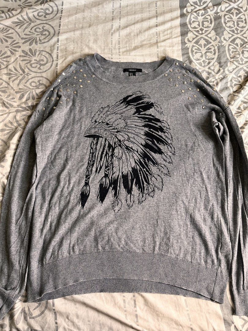 Forever 21 Grey Native Graphic Sweater (Category: Coats, Jackets and Outerwear) located in Manila. Submitted by miyu.ga (Listing ID 1459123031, Image 1). Description: - Grey long-sleeved sweater from Forever 21 - Black Native American chief graphic on front - Studded details on shoulders and upper sleeves - Ribbed cuffs and hem for a snug fit - Made from soft knit material.