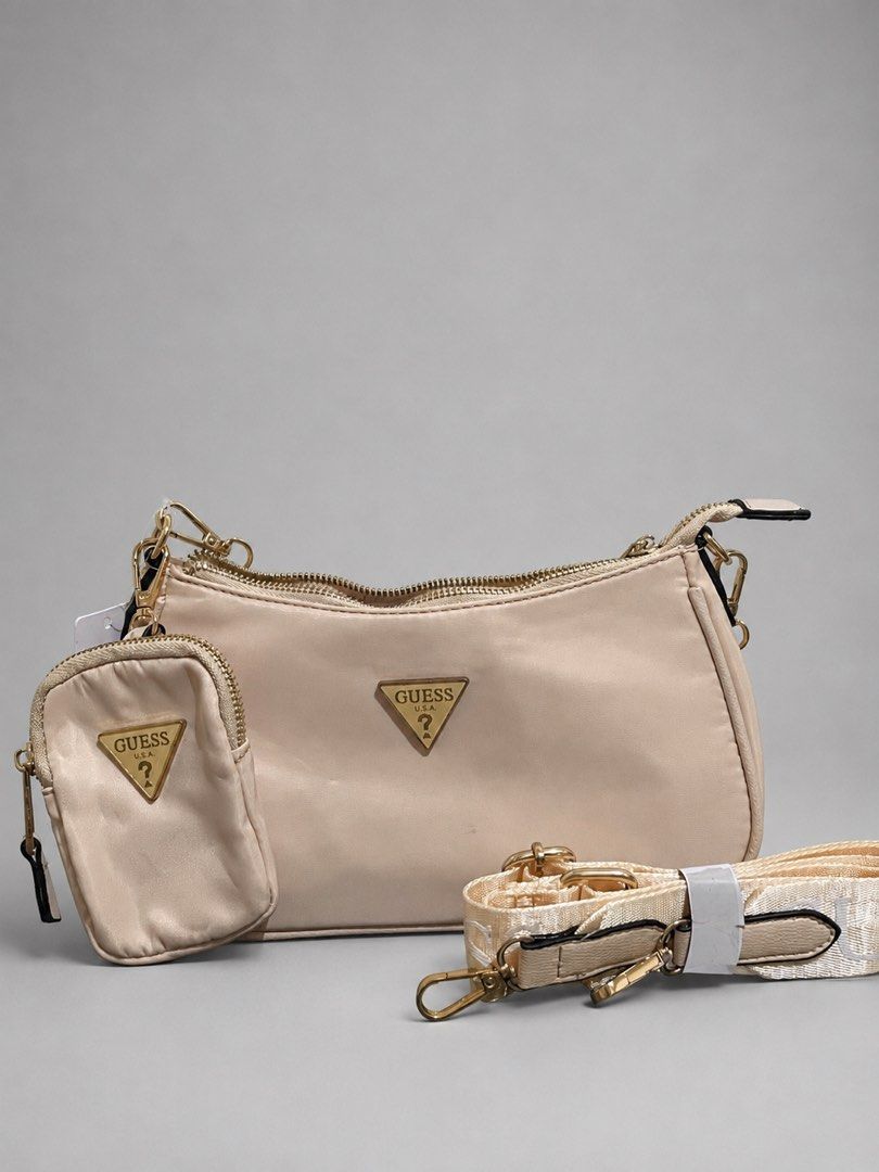 GUESS Nylon Kili & Shoulder Bag (Category: Shoulder Bags) located in Rizal. Submitted by ellabunuan (Listing ID 1459260869, Image 2). Description: 📍Cainta, Rizal If you want to see the actual condition and details of the bag, just message! 📩🛍️ • With mini pouch • Nylon material • Gold hardware •Clean and classy neutral color • excellent condition.