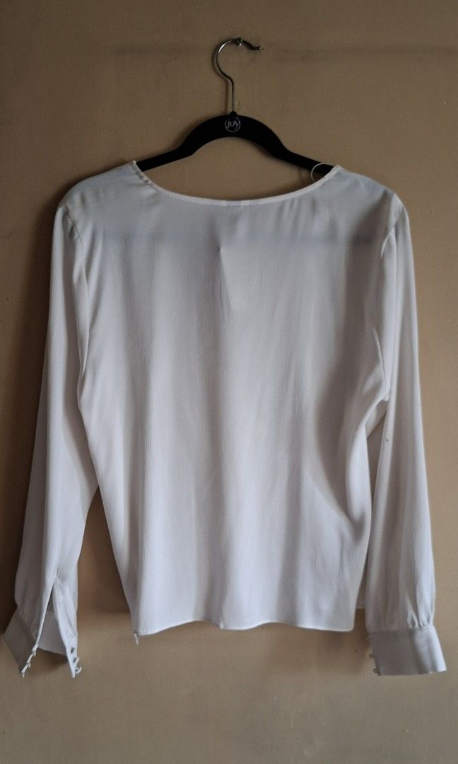 H&M Off White Blouse (Category: Blouses) located in Manila. Submitted by thrifter_lifestyle (Listing ID 1459098553, Image 2). Description: Brand: H&M Long sleeves, button on wrists Wrap style, button mechanism to close in front V Neck Material: Polyester (see tag) Fabric is silk like and flowy. Added close up photos for appreciation. 🙂 Actual Color: Off White/Light Ecru Bust: 40" Length (shoulder to waist): 22" No issues, never worn. With tag, s