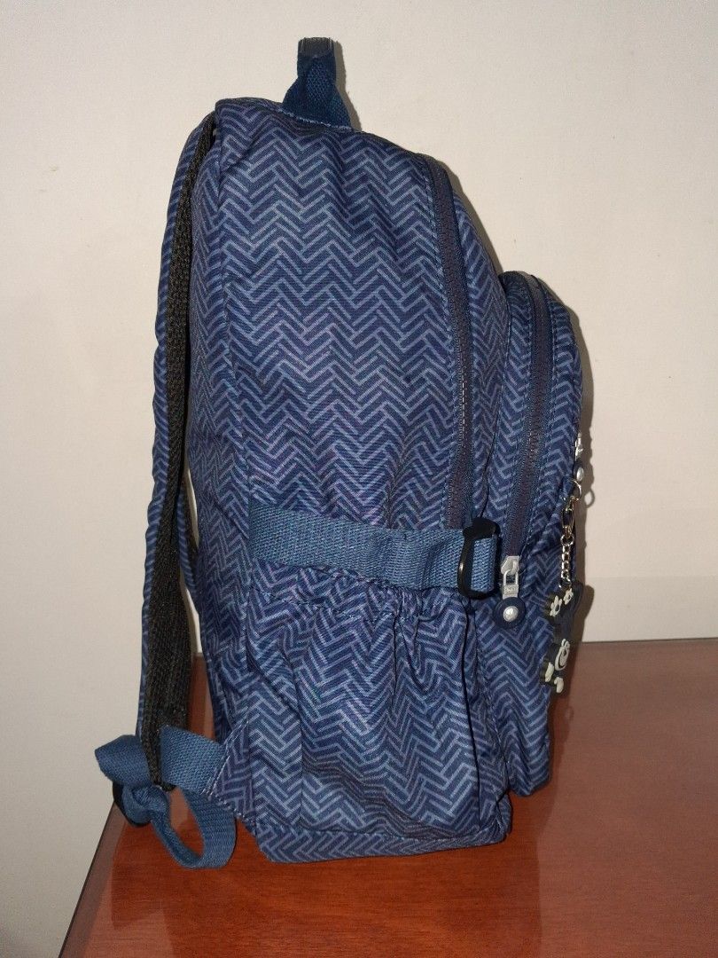 Tegaote Blue Chevron Pattern Backpack with Monkey Charm (Category: Backpacks) located in Angeles City. Submitted by anneps (Listing ID 1459196358, Image 2). Description: - Blue backpack - Stylish chevron pattern - Front zip pocket for easy access - Adjustable straps for comfort - Includes signature Kipling monkey charm - Spacious main compartment - Ideal for school, work, or everyday adventures.