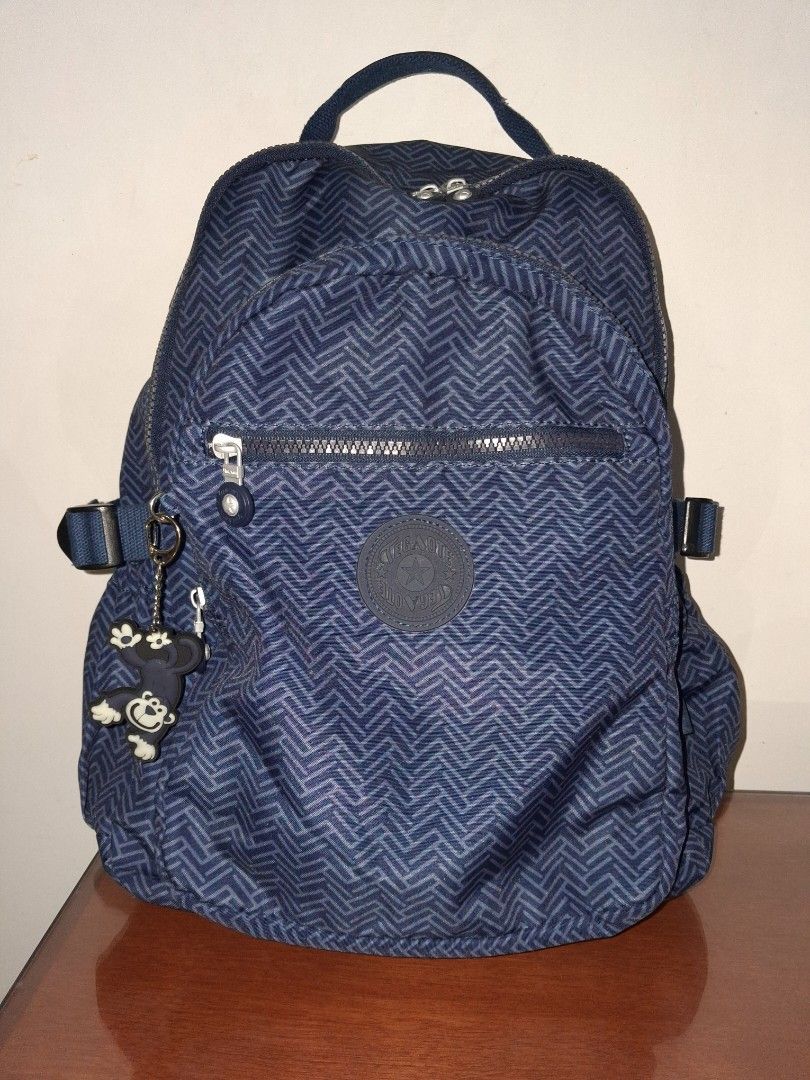 Tegaote Blue Chevron Pattern Backpack with Monkey Charm (Category: Backpacks) located in Angeles City. Submitted by anneps (Listing ID 1459196358, Image 1). Description: - Blue backpack - Stylish chevron pattern - Front zip pocket for easy access - Adjustable straps for comfort - Includes signature Kipling monkey charm - Spacious main compartment - Ideal for school, work, or everyday adventures.