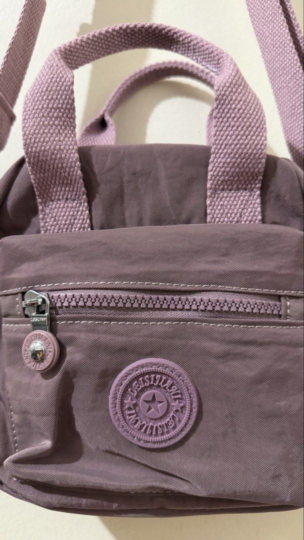 Kipling Inspired Crossbody Bag Lavender Nylon (Category: Cross-body Bags) located in Rizal. Submitted by lovegclothingph (Listing ID 1459215080, Image 2). Description: - Lavender nylon crossbody bag - Has top handles and a detachable shoulder strap - Front zip pocket with a smaller zip pocket inside - Main compartment also has a zip closure. - Small logo on the front - Great for everyday use - RFS: Decluttering.