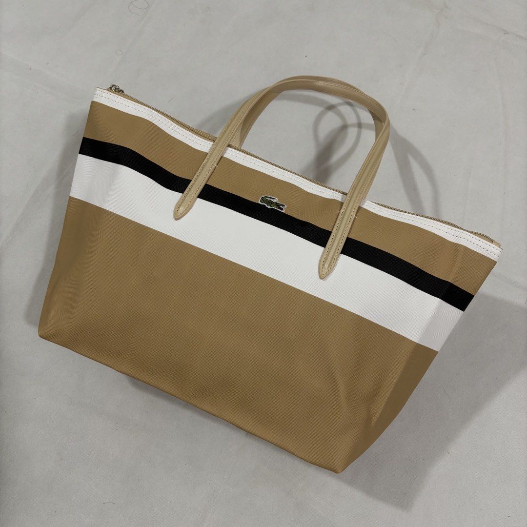 Lacoste Tote Bag - Striped Canvas (Category: Tote Bags) located in Cavite. Submitted by itsayaaa (Listing ID 1459045735, Image 2). Description: - Classic Lacoste tote bag - Horizontal stripes: tan, white, black - Tan leather handles and trim - Zipper closure - Embroidered Lacoste crocodile logo on front - Spacious interior - Ideal for everyday use.