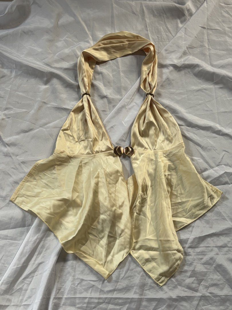 Large SHEIN Satin Buckle Backless Top (Category: Sleeveless) located in Cabuyao City. Submitted by allysanikoru (Listing ID 1459240456, Image 1). Description: Brand: SHEIN Size: Large on tag Tela (Fabric): Satin / Silk Color: Light Yellow Details: Deep V-neckline, gold metal hardware/buckle hook front accent, halter backless design, handkerchief/asymmetrical hem.
