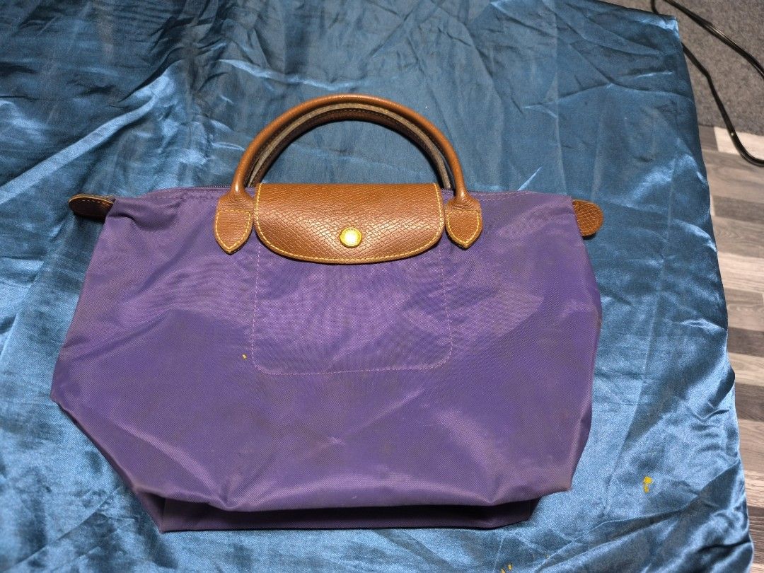 Longchamp Le Pliage Tote Bag (Category: Luxury Bags & Wallets) located in Caloocan City. Submitted by chefems0721 (Listing ID 1459208932, Image 3). Description: - Authentic Longchamp tote bag - Color: Purple and Mustard - Material: Leather handles and trim - Closure: Zipper - Interior: Some marks present - Features: Folds flat for storage - Ideal for: Everyday use - 1K each.