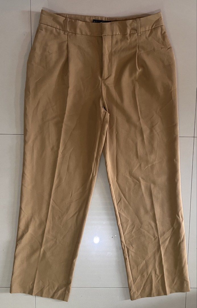 Mango Pleated Wide-Leg Trousers (Camel) (Category: Other Bottoms) located in Malay. Submitted by spacetrips (Listing ID 1459115660, Image 1). Description: Super chic and effortless tailored wide-leg pants from Mango in a gorgeous neutral camel tone. Features classic front pleats, side pockets, belt loops, and a hidden zip/hook closure. Flattering high/mid-rise fit that drapes perfectly. Super versatile—dress them up for the office with a blazer o