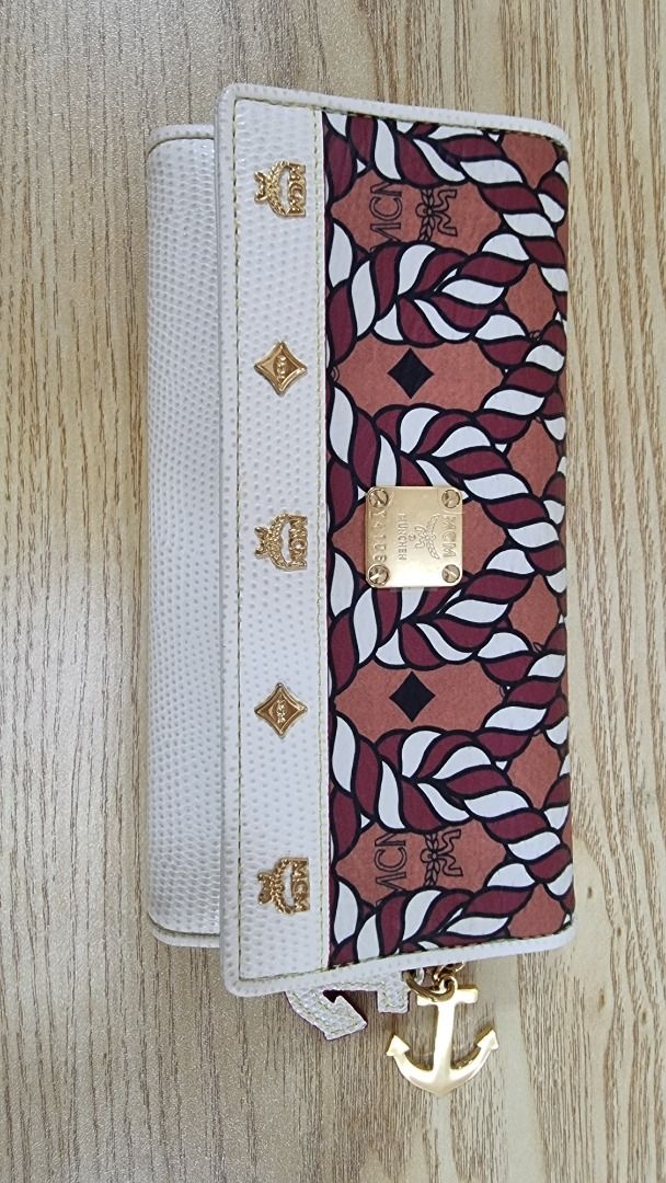MCM Craig Redman Limited Edition Wallet (Category: Luxury Bags & Wallets) located in Paranaque City. Submitted by olxph_668280920 (Listing ID 1459218120, Image 1). Description: - Authentic MCM x Craig Redman collaboration wallet. - Iconic MCM logo print with unique rope and leaf pattern. - White textured leather detailing on the sides. - Elegant gold hardware and a charming anchor accent. - Interior features multiple card slots and a secure zippe