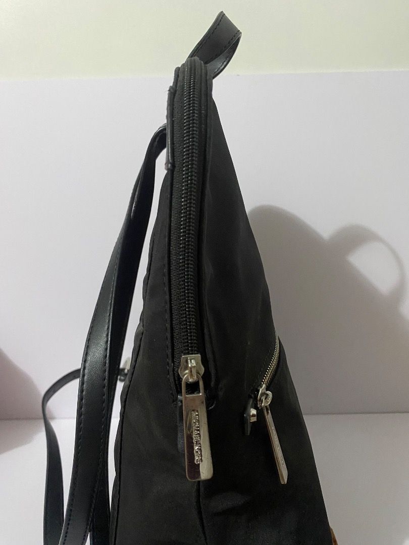Michael Kors Black Nylon Backpack (Category: Backpacks) located in Caloocan City. Submitted by wrenessie (Listing ID 1459230141, Image 3). Description: - Brand: Authentic Michael Kors - Color: Black - Material: Nylon with leather trim - Closure: Zipper - Features: Adjustable straps, front zipper pocket - Condition: Clean inside and out - Ideal for: Everyday use - No flaws.