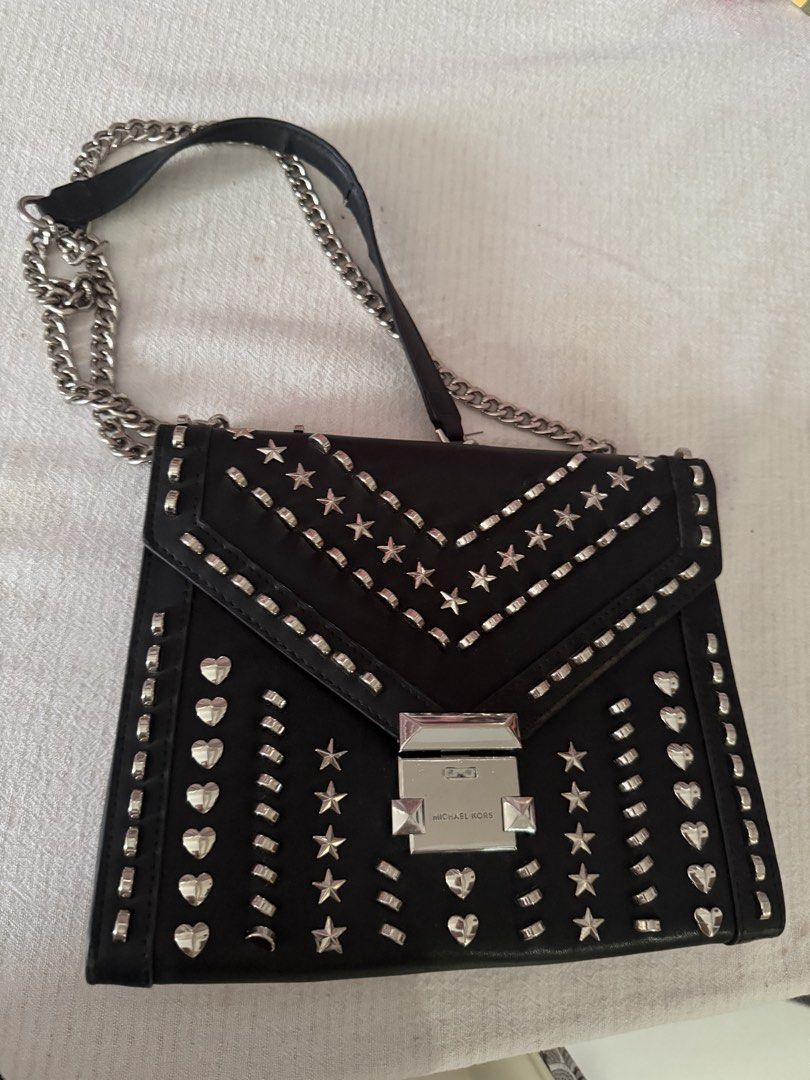 Michael Kors Black Studded Chain Shoulder Bag (Category: Luxury Bags & Wallets) located in Santa Rosa. Submitted by decluttering_. (Listing ID 1459101313, Image 1). Description: - RFS: decluttering - MOP: GCASH - MOD: Lalamove/Jnt - Authentic Michael Kors shoulder bag in black. - Eye-catching silver stud embellishments (stars & hearts) all over. - Stylish silver chain strap. - Secure turn-lock closure at the front. - Spacious interior with a zip 