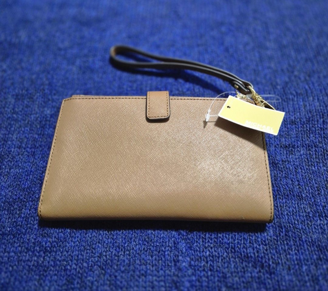 Michael Kors Leather Wallet (Category: Wallets & Card holders) located in Manila. Submitted by sorayabarr50152 (Listing ID 1459210079, Image 2). Description: - Brand: Michael Kors - Color: Tan - Material: Leather - Closure: Zip - Features: Wrist strap - Condition: Brand new with original tags - Ideal for: Carrying your daily essentials.