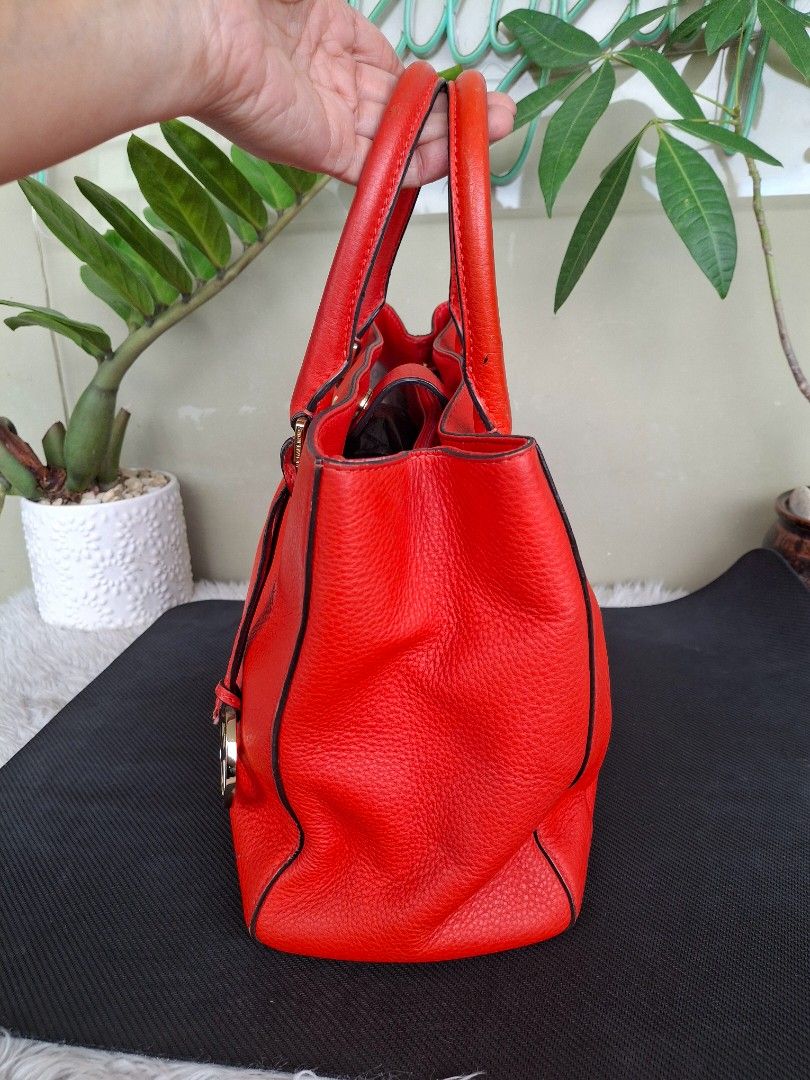 Michael Kors Red Orange Leather Tote Bag (Category: Luxury Bags & Wallets) located in Mandaluyong City. Submitted by shams2026 (Listing ID 1459132087, Image 3). Description: - Genuine red leather Michael Kors tote bag - Classic design with comfortable top handles - Elegant gold hardware accents - Ample interior space for all your essentials - Versatile for everyday wear or evening events - Protective metal feet on the bottom to prevent wear - No 