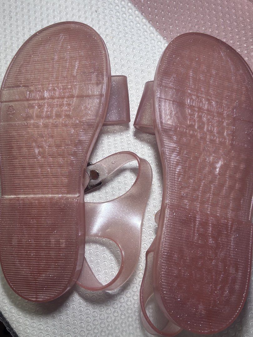 Mini Melissa Pink Glitter Jelly Sandals (Category: Babies & Kids Fashion) located in Del Monte. Submitted by allydap (Listing ID 1459136349, Image 3). Description: - Adorable pink jelly sandals from Mini Melissa - Features sparkly glitter details - Secure buckle strap for a comfortable fit - Ideal for sunny weather and everyday wear - Easy to clean and perfect for active little ones.