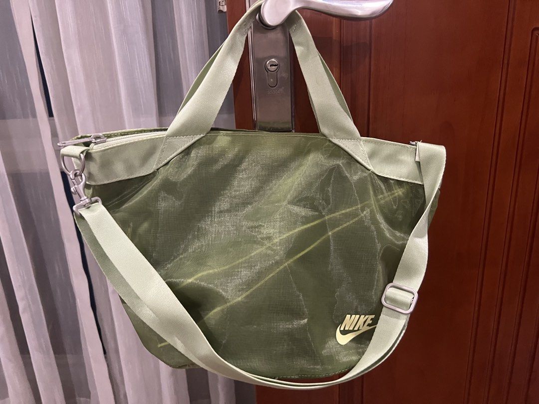 Nike Tote Bag Green (Category: Tote Bags) located in Quezon City. Submitted by anna_rl23 (Listing ID 1459089191, Image 2). Description: Green Nike tote bag. Has top handles and a detachable shoulder strap. The material is lightweight and slightly sheer with subtle lines. Zipper closure at the top. Great for everyday use or gym..