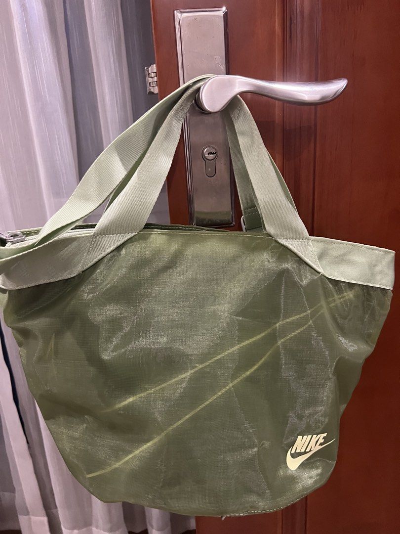 Nike Tote Bag Green (Category: Tote Bags) located in Quezon City. Submitted by anna_rl23 (Listing ID 1459089191, Image 1). Description: Green Nike tote bag. Has top handles and a detachable shoulder strap. The material is lightweight and slightly sheer with subtle lines. Zipper closure at the top. Great for everyday use or gym..