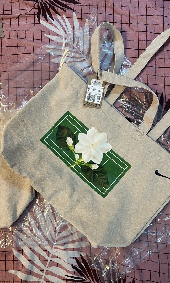 Nike x Alex Eala Tote Bag (Category: Tote Bags) located in Pasig City. Submitted by kcstuffs (Listing ID 1459097175, Image 1). Description: Nike x Alex Eala “In Full Bloom” Sampaguita Canvas Tote Bag The bag is a cream color with a black color Nike swoosh logo embroidered at the upper right corner and has her signature Sampaguita logo on the front side of the bag. Constructed from durable canvas material, suitable for daily errands or tennis gear