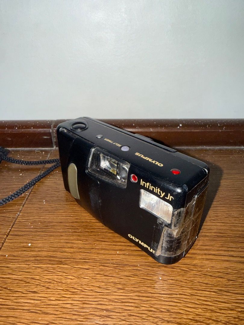 Olympus Infinity Jr (Category: Cameras) located in Caloocan City. Submitted by stevendgzmn (Listing ID 1459204878, Image 3). Description: Condition: * No film included * No battery included * Untested due to no battery/film * Shows signs of use, scratches, and cosmetic wear * Battery door has been secured with tape, as shown in the photos * Some wear and discoloration on the exterior * Lens and internal components are present * Functionality is n