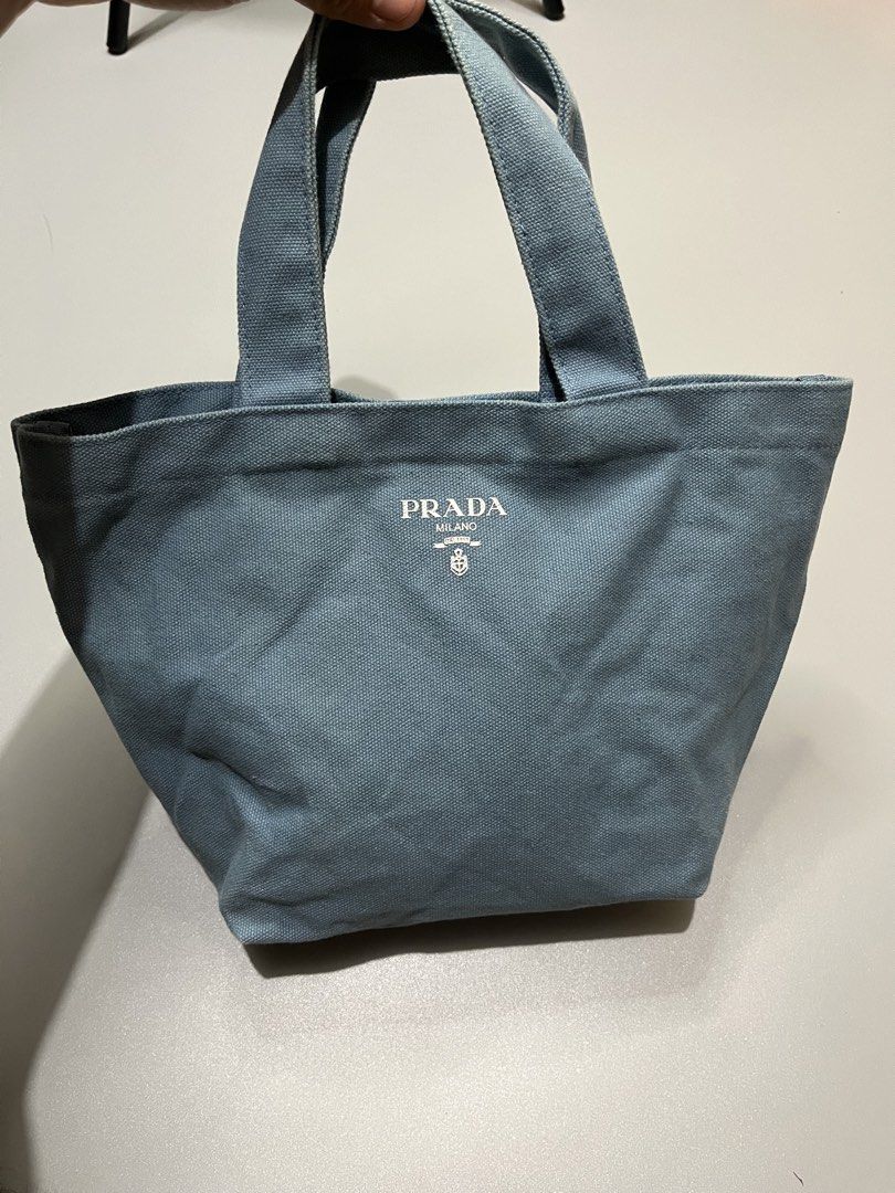 Prada Canvas Tote Bag (Category: Luxury Bags & Wallets) located in Manila. Submitted by jorgemabelin2001 (Listing ID 1459108449, Image 1). Description: - Light blue Prada canvas tote bag - Simple and classic design, perfect for everyday use - Features sturdy handles for durability - Iconic Prada logo printed on the front - Compact size, ideal for carrying your essentials.