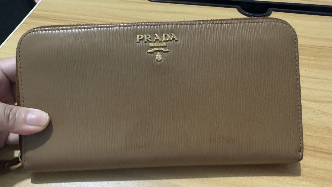 PRELOVED Prada Saffiano Double Zip Around Wallet (Category: Luxury Bags & Wallets) located in Quezon City. Submitted by mrsp_28 (Listing ID 1459100111, Image 3). Description: - Authentic Prada Wallet - Material: Saffiano Leather - Color: Brown - Closure: Zip-around - Includes: Authenticity Card MOP: BPI/GCASH/MARIBANK.