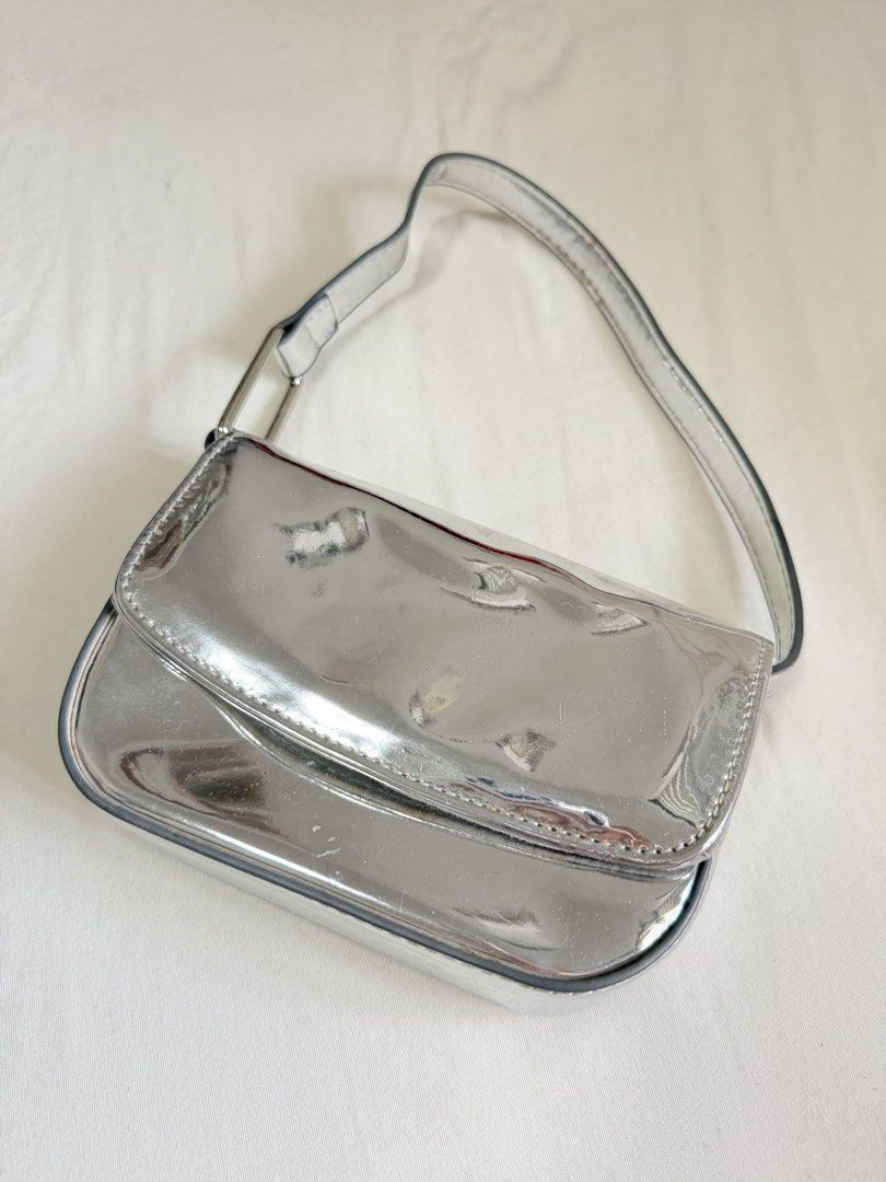 STRADIVARIUS Silver Metallic Shoulder Bag (Category: Shoulder Bags) located in Pasig City. Submitted by miss_abuelita (Listing ID 1459158041, Image 1). Description: - Cute silver shoulder bag - Shiny metallic finish - Main compartment with a smaller inner pocket - Secure snap closure - Adjustable strap - Ideal for going out or adding a pop of shine to any outfit.