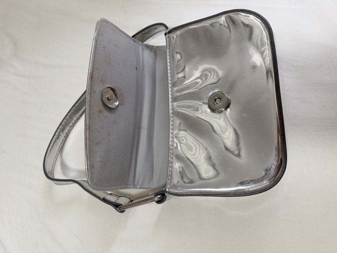 STRADIVARIUS Silver Metallic Shoulder Bag (Category: Shoulder Bags) located in Pasig City. Submitted by miss_abuelita (Listing ID 1459158041, Image 3). Description: - Cute silver shoulder bag - Shiny metallic finish - Main compartment with a smaller inner pocket - Secure snap closure - Adjustable strap - Ideal for going out or adding a pop of shine to any outfit.