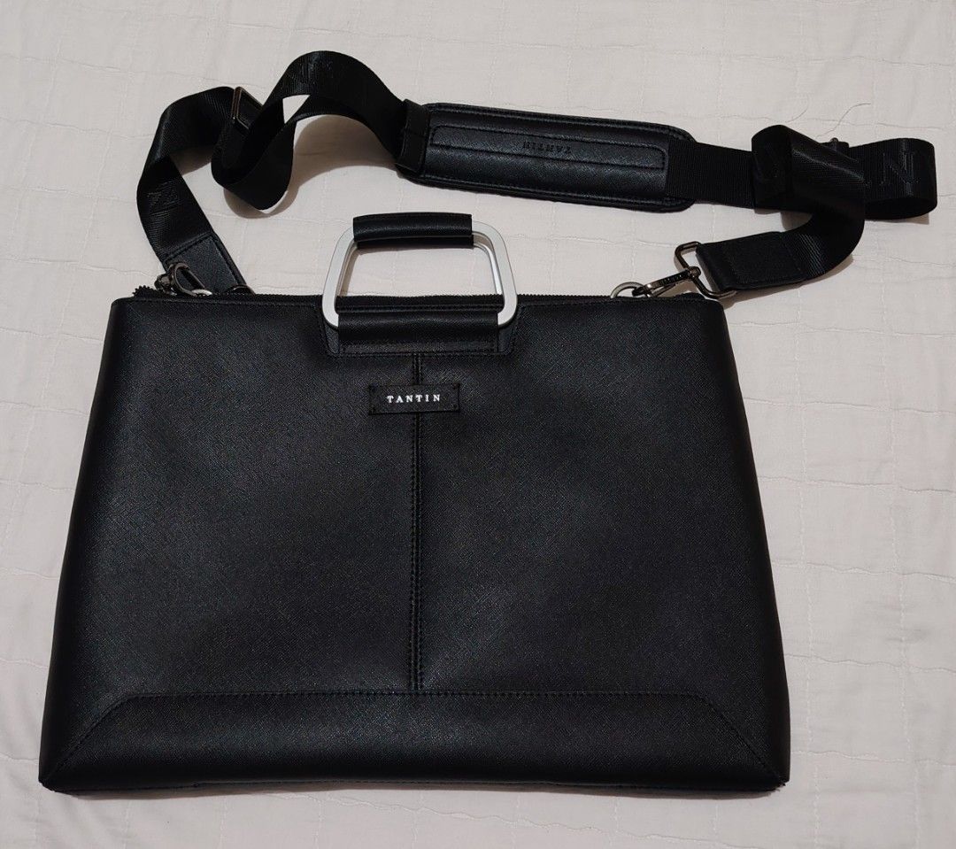 TANTIN Black Laptop Bag with Shoulder Strap (Category: Laptop Bags & Sleeves) located in Davao. Submitted by dareyl_121422 (Listing ID 1459142234, Image 1). Description: - Sleek black TANTIN laptop bag - Elegant silver handles - Detachable shoulder strap for versatile carrying - Bright blue interior lining with convenient pockets - Smooth, reliable zippers - Brand name clearly visible on hardware and strap - Ideal for work, school, or travel.