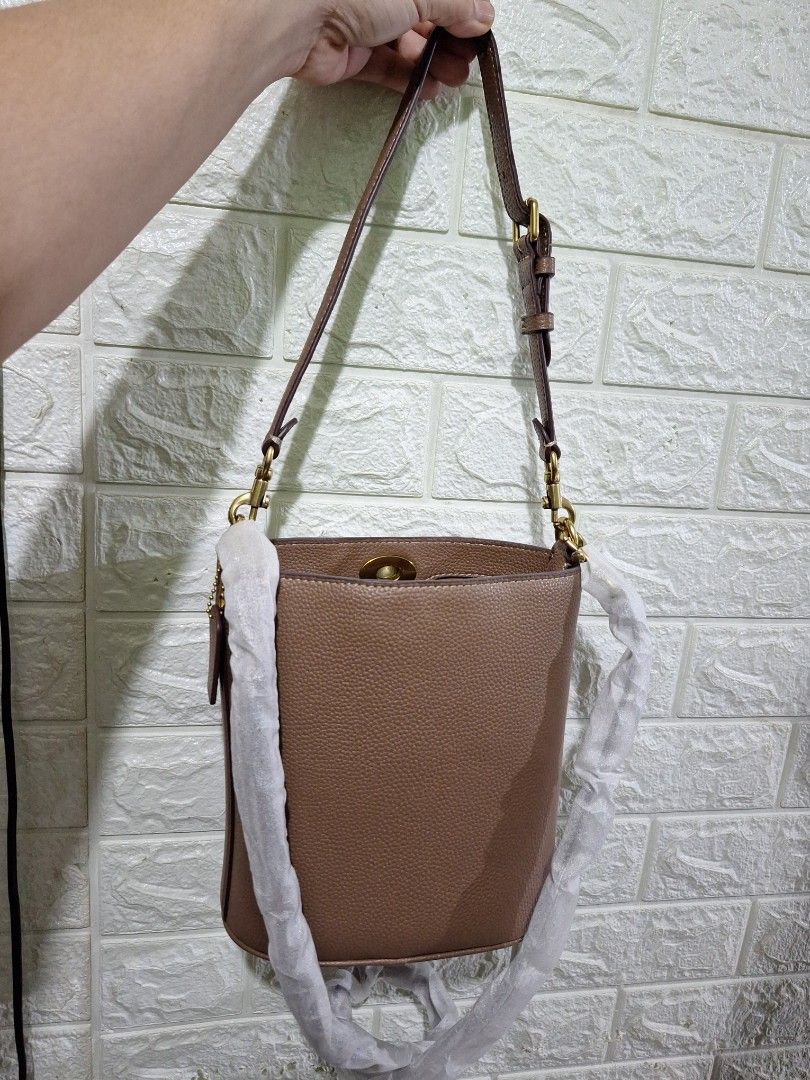 Taupe Leather Handbag with Gold Hardware (Category: Luxury Bags & Wallets) located in Manila. Submitted by bagelyaniellen (Listing ID 1459097279, Image 3). Description: - Taupe leather handbag - Secure turn-lock closure with elegant gold hardware - Four protective feet on the base - Minor scuffs visible on the bottom edge - Stylish chain strap detail - Ideal size for carrying everyday essentials.